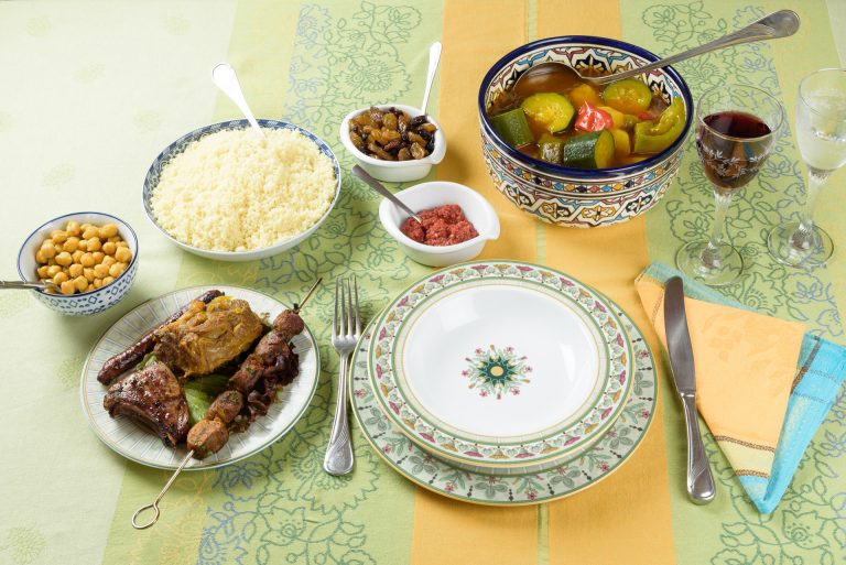 Table marocaine : couscous, légumes, grillades, pois chiches et condiments